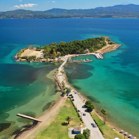 Aerial drone photo of famous island of dreams or Pesonisi connecting with small road with seaside fishing village of Eretria, Central Evia island, Greece